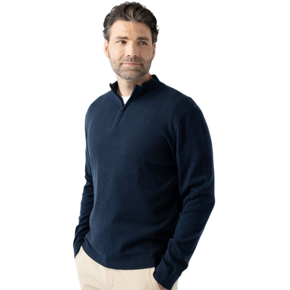 A man with dark hair and a short beard is wearing a navy blue Men's Quarter Zip Sweater from Cozy Earth paired with beige pants. He stands with his hands in his pockets against a plain white background, looking to his right with a slight smile. |Color:Eclipse