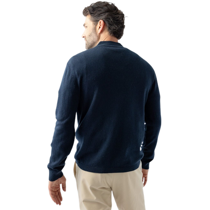 A man with dark hair and a short beard is wearing a navy blue Men's Quarter Zip Sweater from Cozy Earth paired with beige pants. He stands with his hands in his pockets against a plain white background, looking to his right with a slight smile. |Color:Eclipse