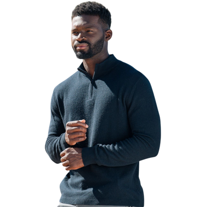 A man with dark hair and a short beard is wearing a navy blue Men's Quarter Zip Sweater from Cozy Earth paired with beige pants. He stands with his hands in his pockets against a plain white background, looking to his right with a slight smile. |Color:Eclipse