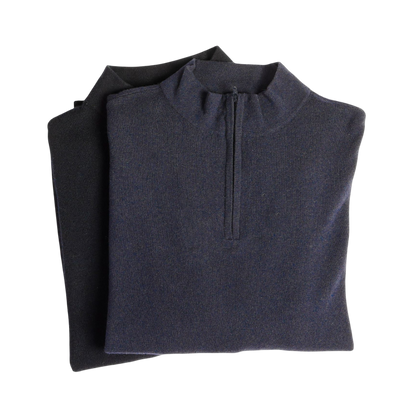 A man with dark hair and a short beard is wearing a navy blue Men's Quarter Zip Sweater from Cozy Earth paired with beige pants. He stands with his hands in his pockets against a plain white background, looking to his right with a slight smile. |Color:Eclipse