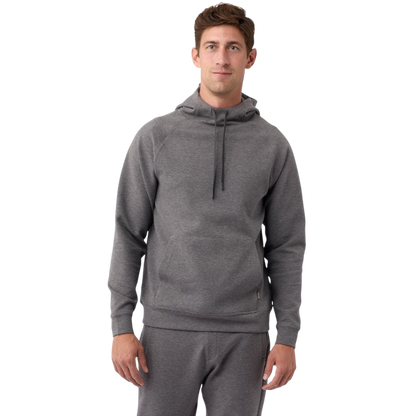 A person wearing the Men's StretchTech Hoodie from Cozy Earth, paired with matching gray pants, stands against a plain white background. The hoodie features drawstrings and a front pocket. The individual is looking forward with a neutral expression. |Color:Coal Heather