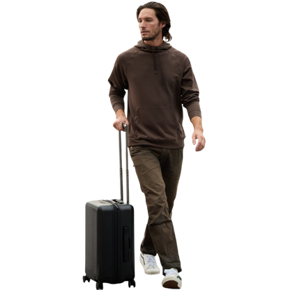 A person wearing the Men's StretchTech Hoodie from Cozy Earth, paired with matching gray pants, stands against a plain white background. The hoodie features drawstrings and a front pocket. The individual is looking forward with a neutral expression. |Color:Coal Heather