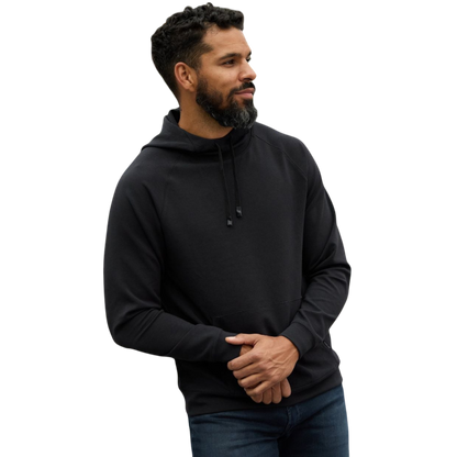 A person wearing the Men's StretchTech Hoodie from Cozy Earth, paired with matching gray pants, stands against a plain white background. The hoodie features drawstrings and a front pocket. The individual is looking forward with a neutral expression. |Color:Coal Heather