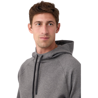 A person wearing the Men's StretchTech Hoodie from Cozy Earth, paired with matching gray pants, stands against a plain white background. The hoodie features drawstrings and a front pocket. The individual is looking forward with a neutral expression. |Color:Coal Heather