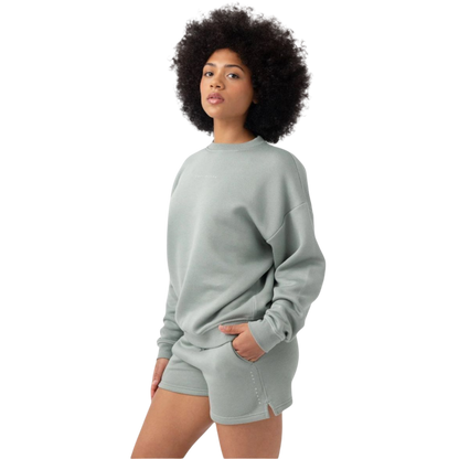 Haze CityScape Pullover Crew. The Pullover is being worn by a female model. Accompanying city scape clothing is being worn to complete the look of the outfit. The photo was taken with a white background. |Color:Haze