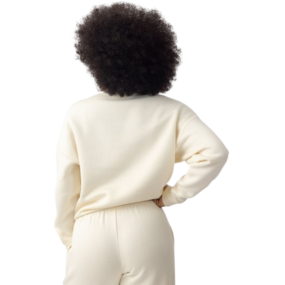 A person with curly hair models the Cozy Earth Women's CityScape Crewneck and matching pants in light pink against a plain white backdrop. |Color:Peony