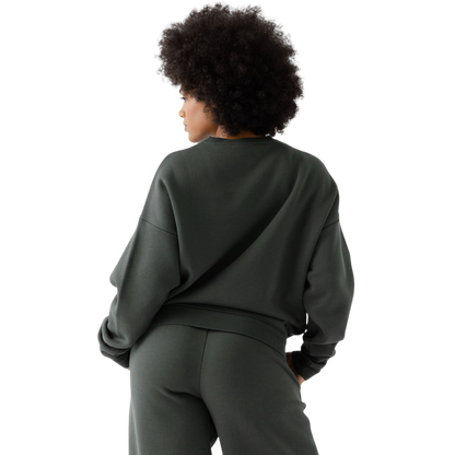 A person with curly hair models the Cozy Earth Women's CityScape Crewneck and matching pants in light pink against a plain white backdrop. |Color:Peony