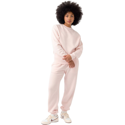 A person with curly hair models the Cozy Earth Women's CityScape Crewneck and matching pants in light pink against a plain white backdrop. |Color:Peony