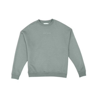 A person with curly hair models the Cozy Earth Women's CityScape Crewneck and matching pants in light pink against a plain white backdrop. |Color:Peony
