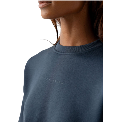 A person with curly hair models the Cozy Earth Women's CityScape Crewneck and matching pants in light pink against a plain white backdrop. |Color:Peony