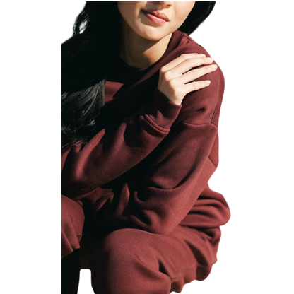 A person with curly hair models the Cozy Earth Women's CityScape Crewneck and matching pants in light pink against a plain white backdrop. |Color:Peony