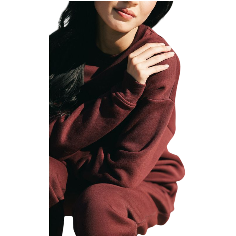 A person with curly hair models the Cozy Earth Women's CityScape Crewneck and matching pants in light pink against a plain white backdrop. |Color:Peony