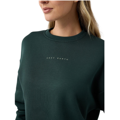 A person with curly hair models the Cozy Earth Women's CityScape Crewneck and matching pants in light pink against a plain white backdrop. |Color:Peony