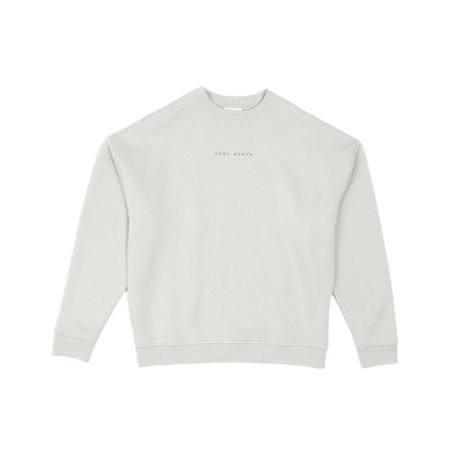 A person with curly hair models the Cozy Earth Women's CityScape Crewneck and matching pants in light pink against a plain white backdrop. |Color:Peony