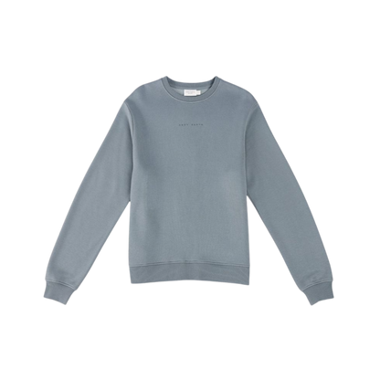 A person with curly hair models the Cozy Earth Women's CityScape Crewneck and matching pants in light pink against a plain white backdrop. |Color:Peony