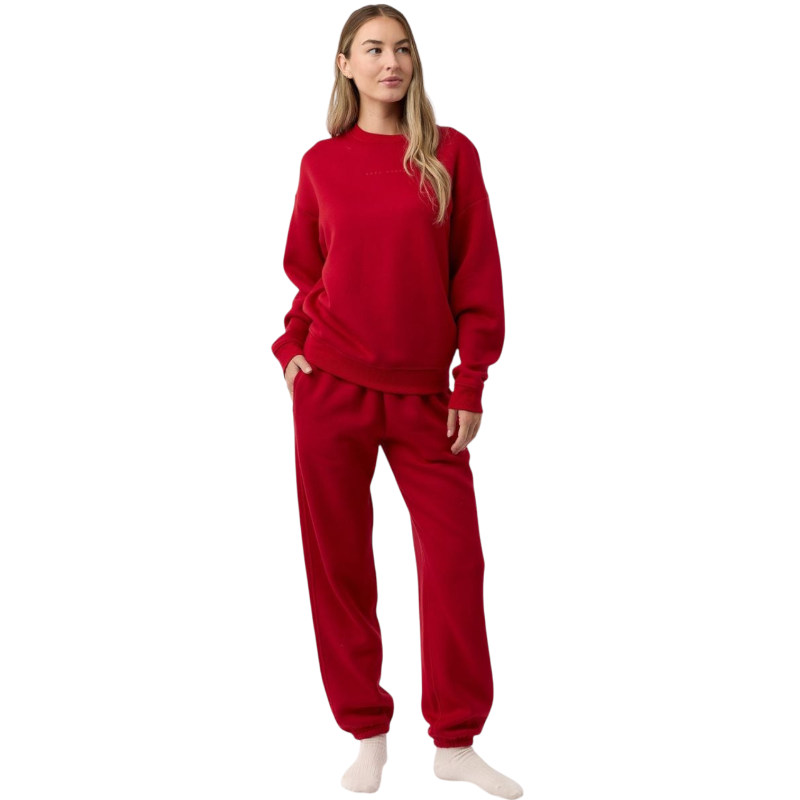 A person with curly hair models the Cozy Earth Women's CityScape Crewneck and matching pants in light pink against a plain white backdrop. |Color:Peony