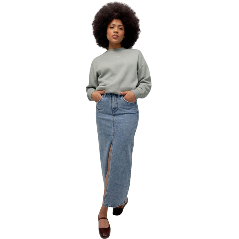 A person with curly hair models the Cozy Earth Women's CityScape Crewneck and matching pants in light pink against a plain white backdrop. |Color:Peony