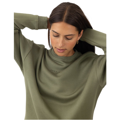 A person with curly hair models the Cozy Earth Women's CityScape Crewneck and matching pants in light pink against a plain white backdrop. |Color:Peony