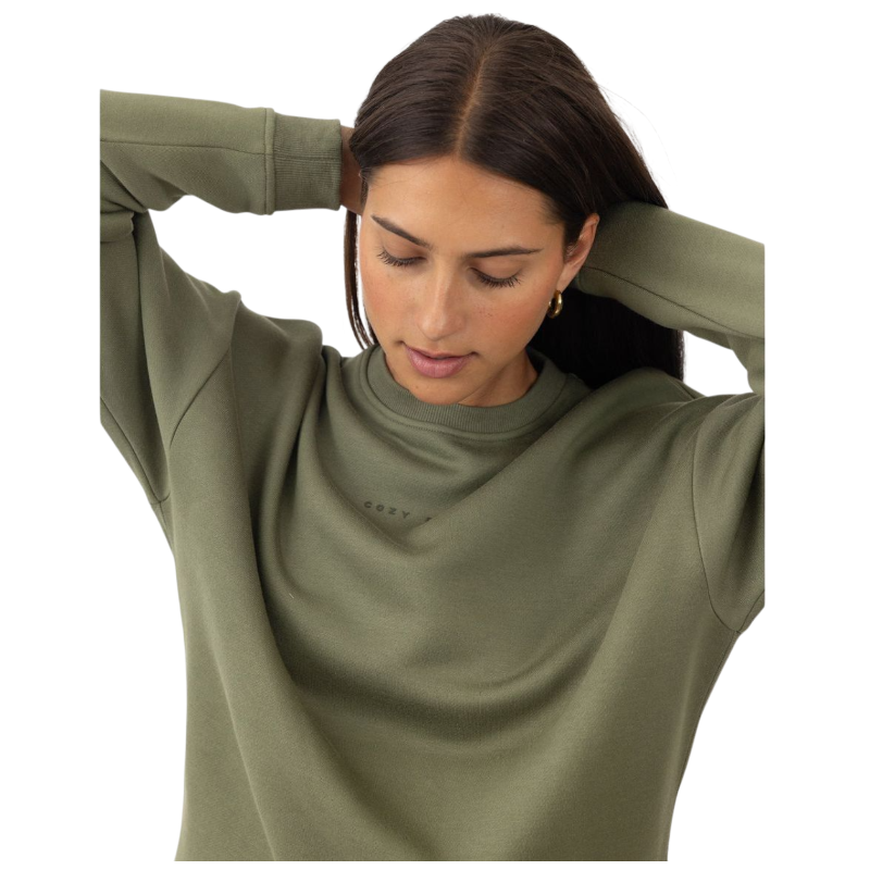 A person with curly hair models the Cozy Earth Women's CityScape Crewneck and matching pants in light pink against a plain white backdrop. |Color:Peony