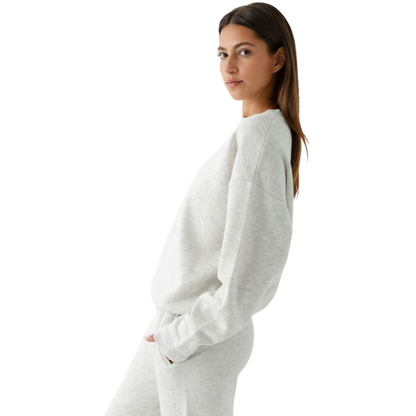 A person with curly hair models the Cozy Earth Women's CityScape Crewneck and matching pants in light pink against a plain white backdrop. |Color:Peony