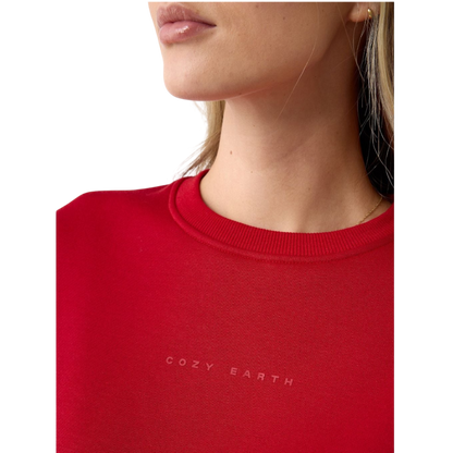 A person with curly hair models the Cozy Earth Women's CityScape Crewneck and matching pants in light pink against a plain white backdrop. |Color:Peony
