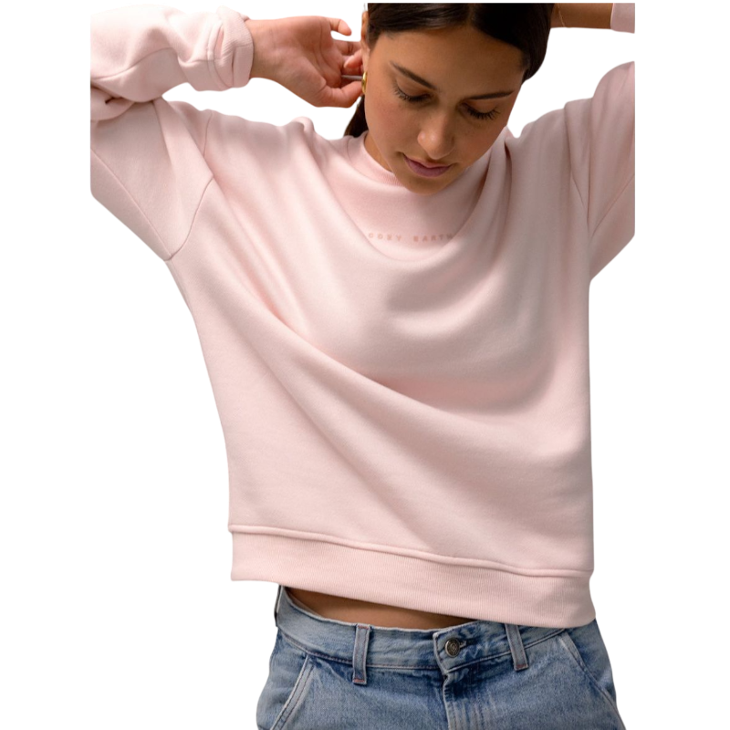 A person with curly hair models the Cozy Earth Women's CityScape Crewneck and matching pants in light pink against a plain white backdrop. |Color:Peony