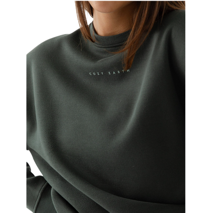 A person with curly hair models the Cozy Earth Women's CityScape Crewneck and matching pants in light pink against a plain white backdrop. |Color:Peony