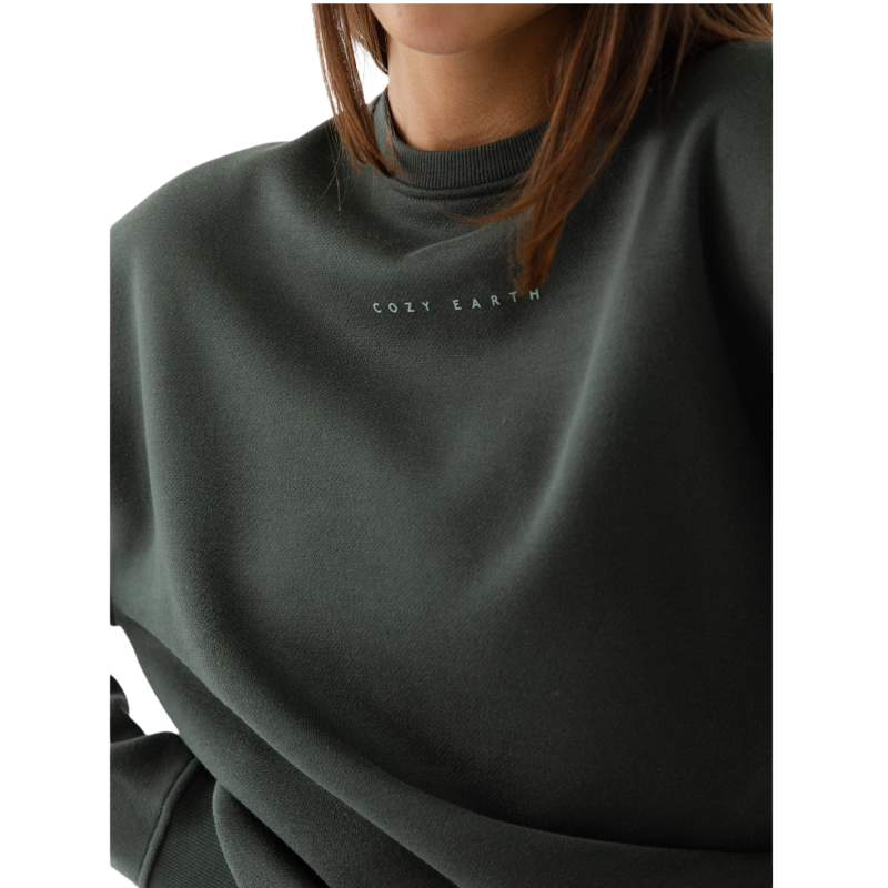 A person with curly hair models the Cozy Earth Women's CityScape Crewneck and matching pants in light pink against a plain white backdrop. |Color:Peony