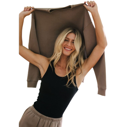 A person with curly hair models the Cozy Earth Women's CityScape Crewneck and matching pants in light pink against a plain white backdrop. |Color:Peony