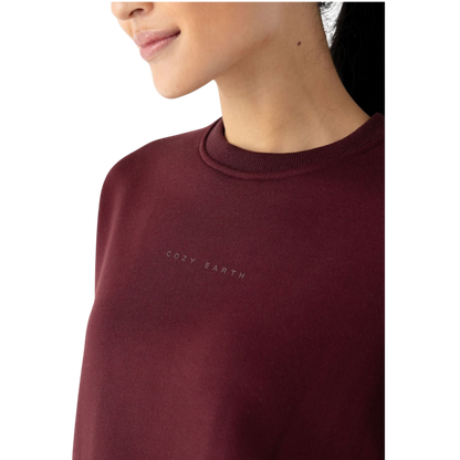 A person with curly hair models the Cozy Earth Women's CityScape Crewneck and matching pants in light pink against a plain white backdrop. |Color:Peony