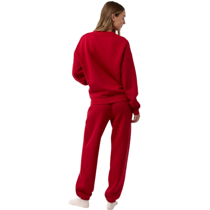 A person with curly hair models the Cozy Earth Women's CityScape Crewneck and matching pants in light pink against a plain white backdrop. |Color:Peony