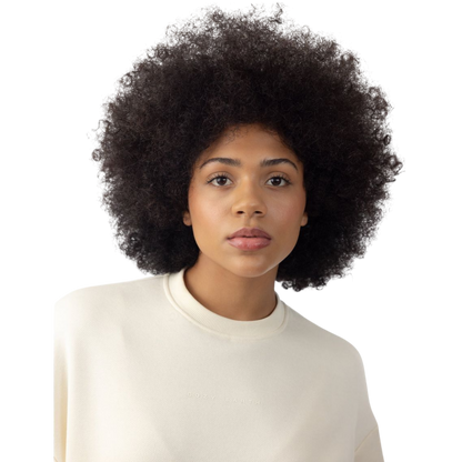 A person with curly hair models the Cozy Earth Women's CityScape Crewneck and matching pants in light pink against a plain white backdrop. |Color:Peony
