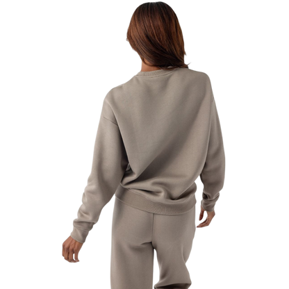A person with curly hair models the Cozy Earth Women's CityScape Crewneck and matching pants in light pink against a plain white backdrop. |Color:Peony