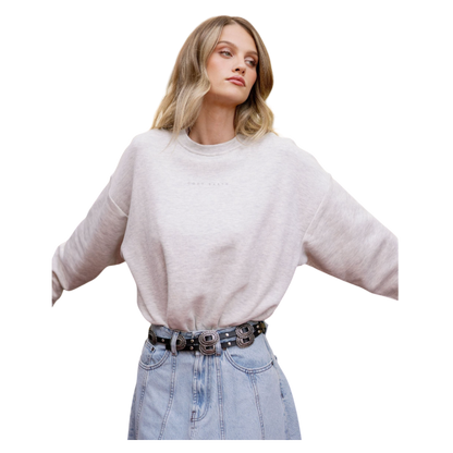 A person with curly hair models the Cozy Earth Women's CityScape Crewneck and matching pants in light pink against a plain white backdrop. |Color:Peony