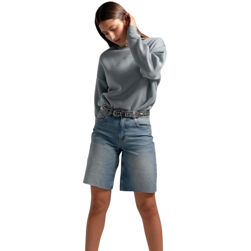 A person with curly hair models the Cozy Earth Women's CityScape Crewneck and matching pants in light pink against a plain white backdrop. |Color:Peony