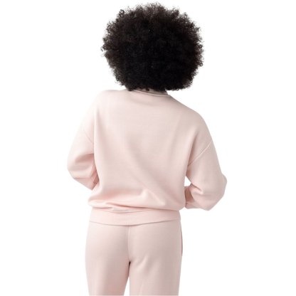A person with curly hair models the Cozy Earth Women's CityScape Crewneck and matching pants in light pink against a plain white backdrop. |Color:Peony